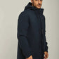 Man wearing a navy blue hooded winter jacket and blue jeans, casual fashion