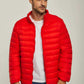 Man wearing a bright red puffer jacket over a white t-shirt and blue jeans