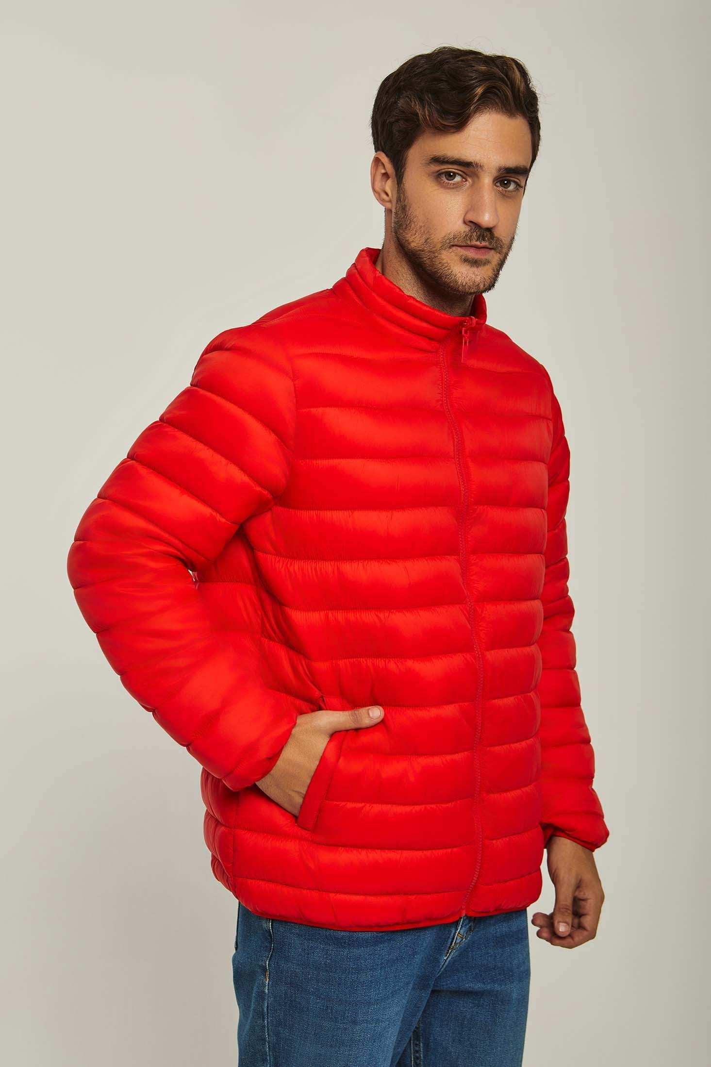 Man wearing a bright red puffer jacket with front zip and blue jeans, casual style