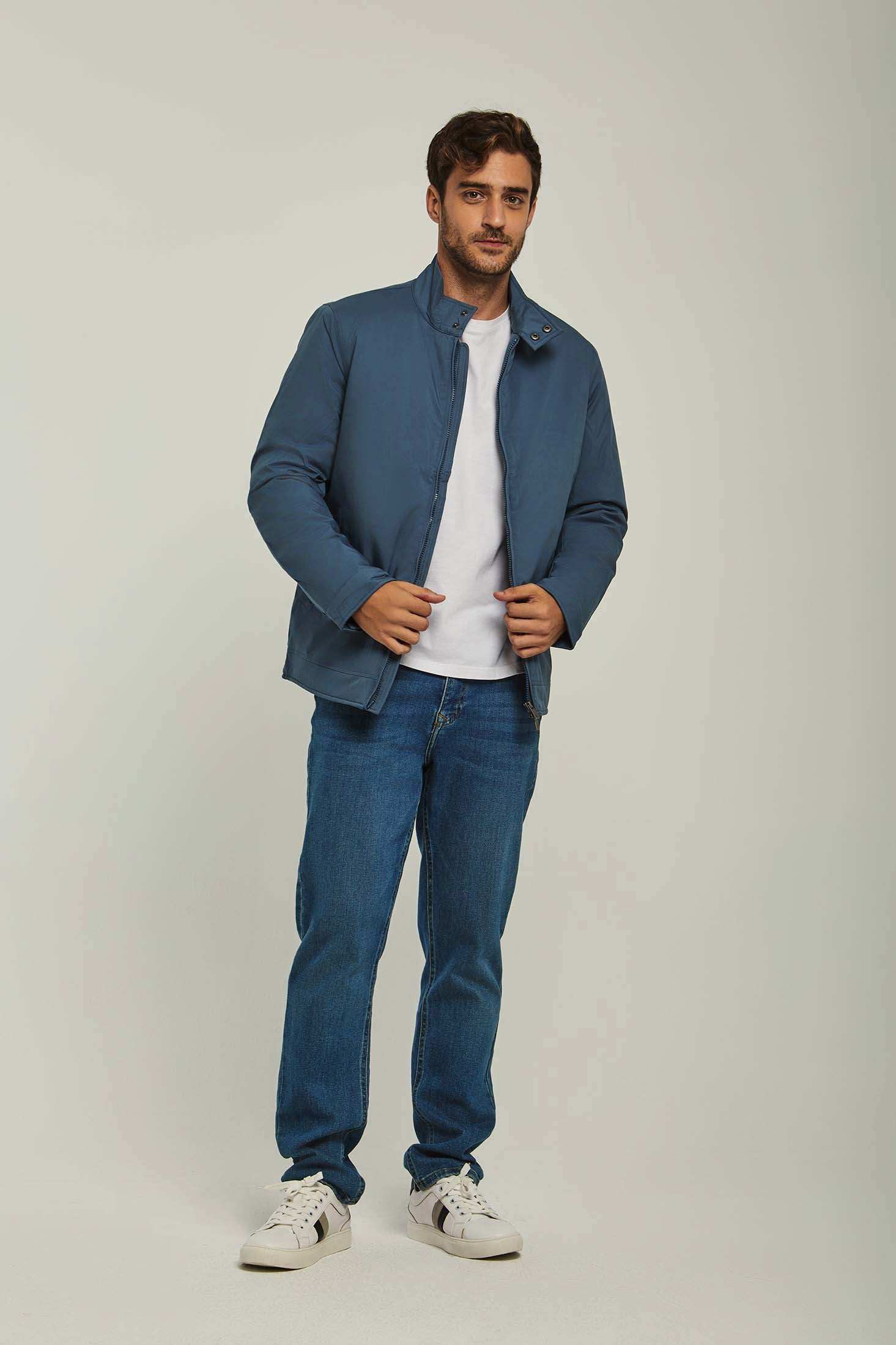 Man wearing a blue casual jacket, white t-shirt, blue jeans, and white sneakers