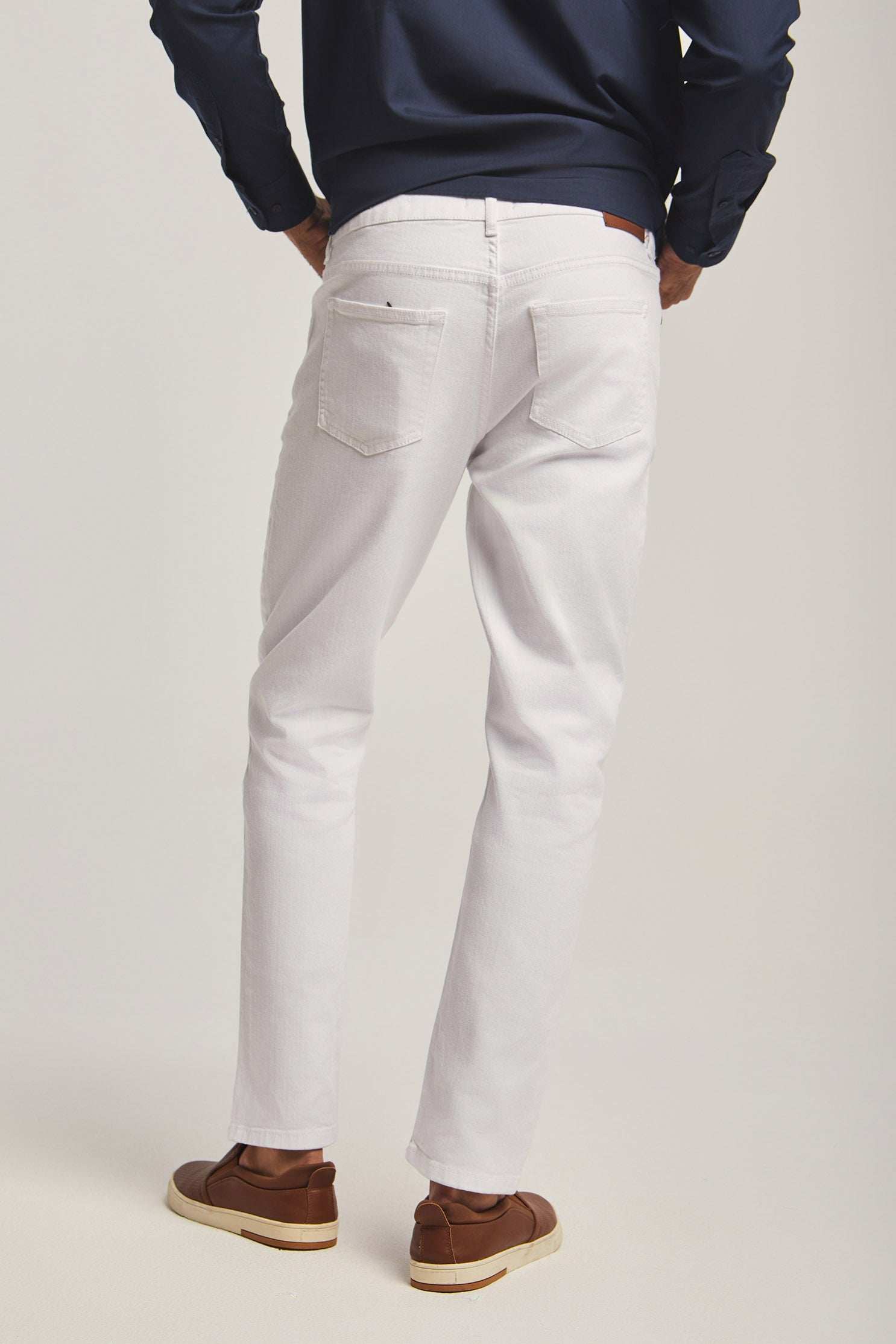 Dalydress men's white jeans, back view, styled with brown shoes and navy shirt