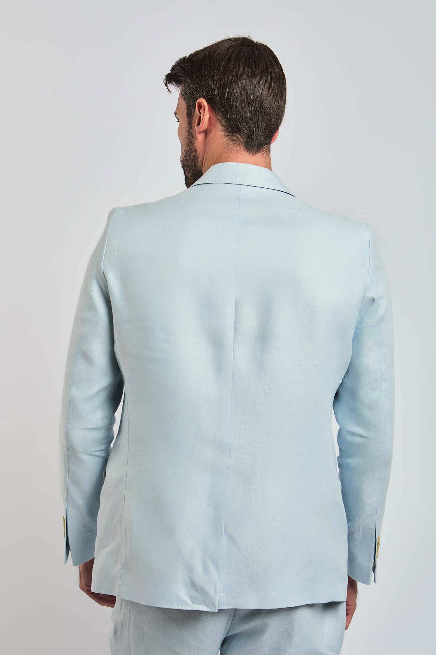 Back view of man wearing light blue Dalydress suit against plain background