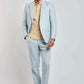 Man modeling Dalydress light blue suit with beige polo shirt and brown sneakers
