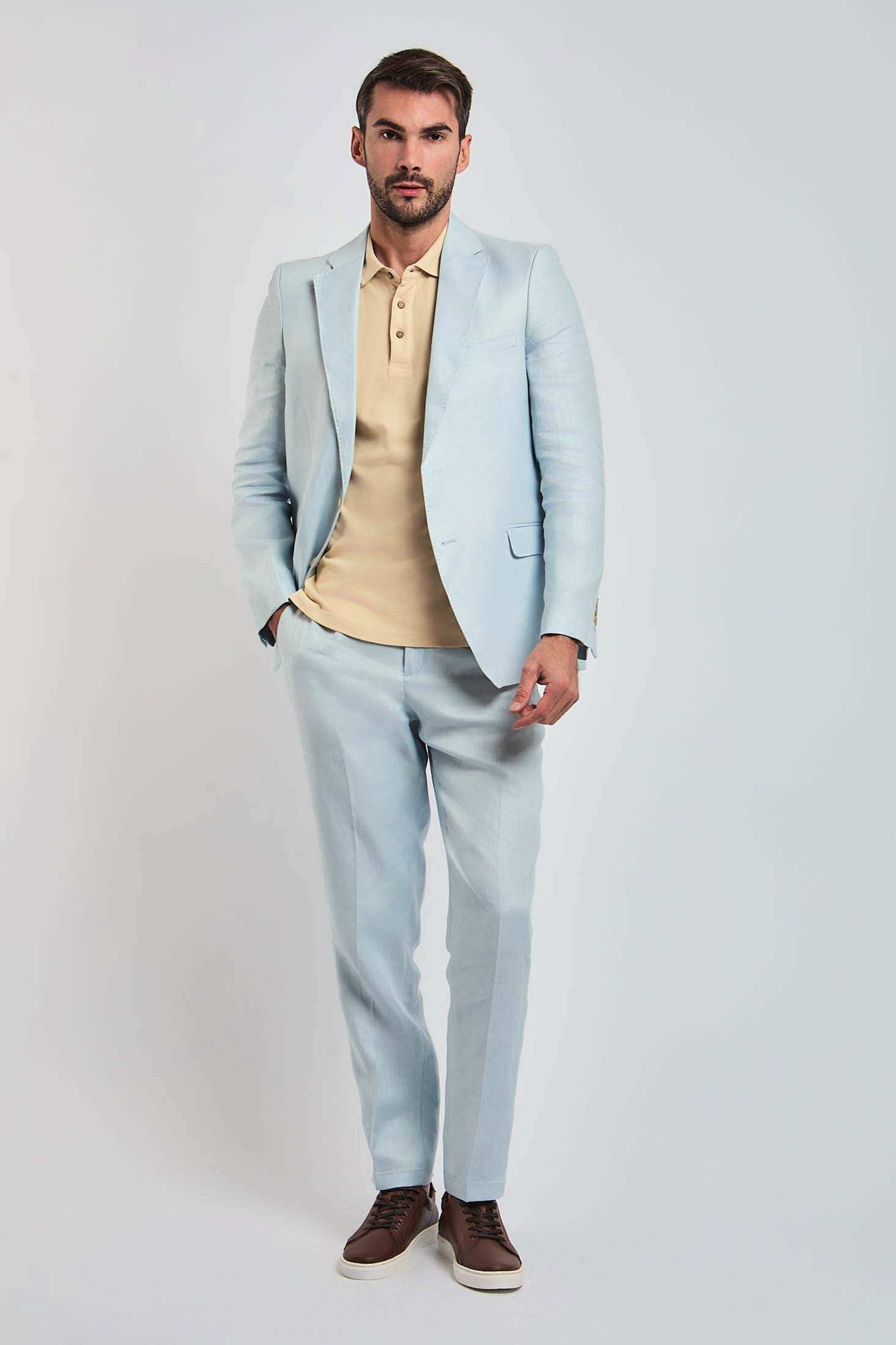 Man modeling Dalydress light blue suit with beige polo shirt and brown sneakers