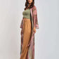 Woman in casual chic outfit with green crop top, tan high-waisted pants, and sheer pink kimono