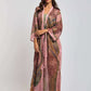 Woman wearing a long, sheer printed kimono over brown wide-leg pants, fashion photoshoot