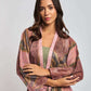 Woman wearing a pink and brown floral kimono-style dress with long sleeves