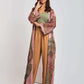Woman wearing a green top, light brown pants, and a long patterned kimono jacket