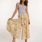 Woman wearing a lilac tank top and floral wide-leg pants from Dalydress against a white background