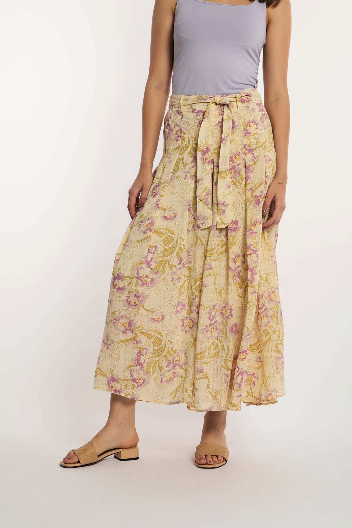 Woman wearing Dalydress yellow floral maxi skirt with tie belt and lilac top