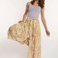 Woman in lilac tank top and floral maxi skirt from Dalydress, posing on white background