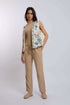 Woman wearing beige pants, tan top, and embroidered vest from Dalydress, standing in studio