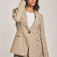 Woman wearing beige linen blazer and pants set from Dalydress against neutral background