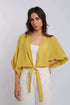 Woman wearing Dalydress yellow tie-front blouse and white studded pants