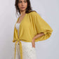 Woman in yellow tie-front blouse and white studded pants from Dalydress casual collection
