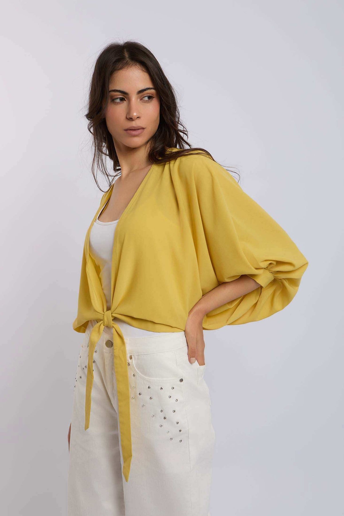 Woman in yellow tie-front blouse and white studded pants from Dalydress casual collection