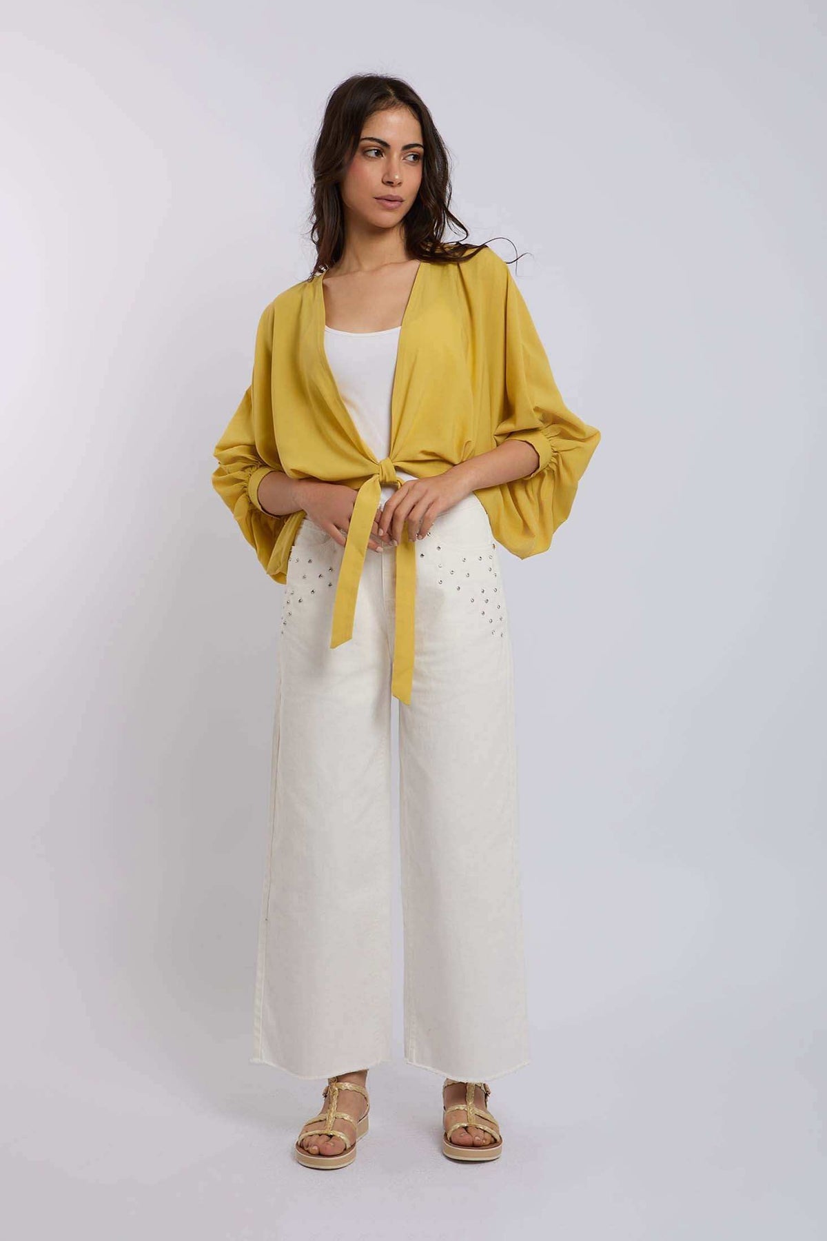 Woman wearing yellow tie-front blouse and white wide-leg pants from Dalydress fashion collection