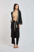 Woman wearing Dalydress black kimono set with geometric trim and beige top, standing in studio