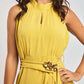 Woman wearing sleeveless yellow Dalydress dress with ruffled neck and gold floral belt accent