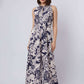 Woman in Dalydress sleeveless navy floral maxi dress, standing against light background