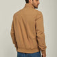 Man wearing a tan casual jacket and blue jeans, shown from the back on a neutral background.