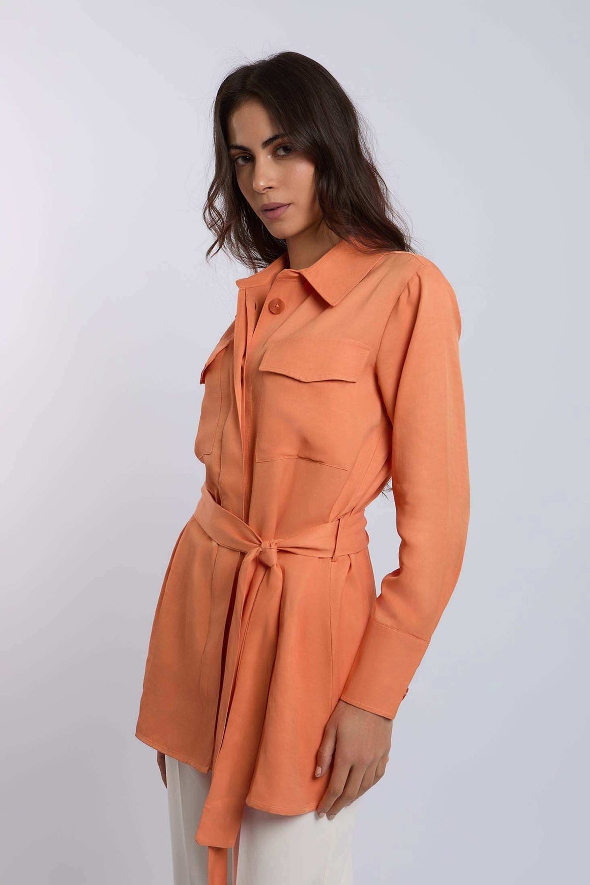 Woman wearing an orange belted shirt with front pockets, Dalydress women's fashion.