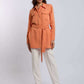 Woman wearing a peach belted shirt and white pants from Dalydress, modern casual style