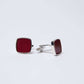 Square silver cufflinks with textured red inlay on white background