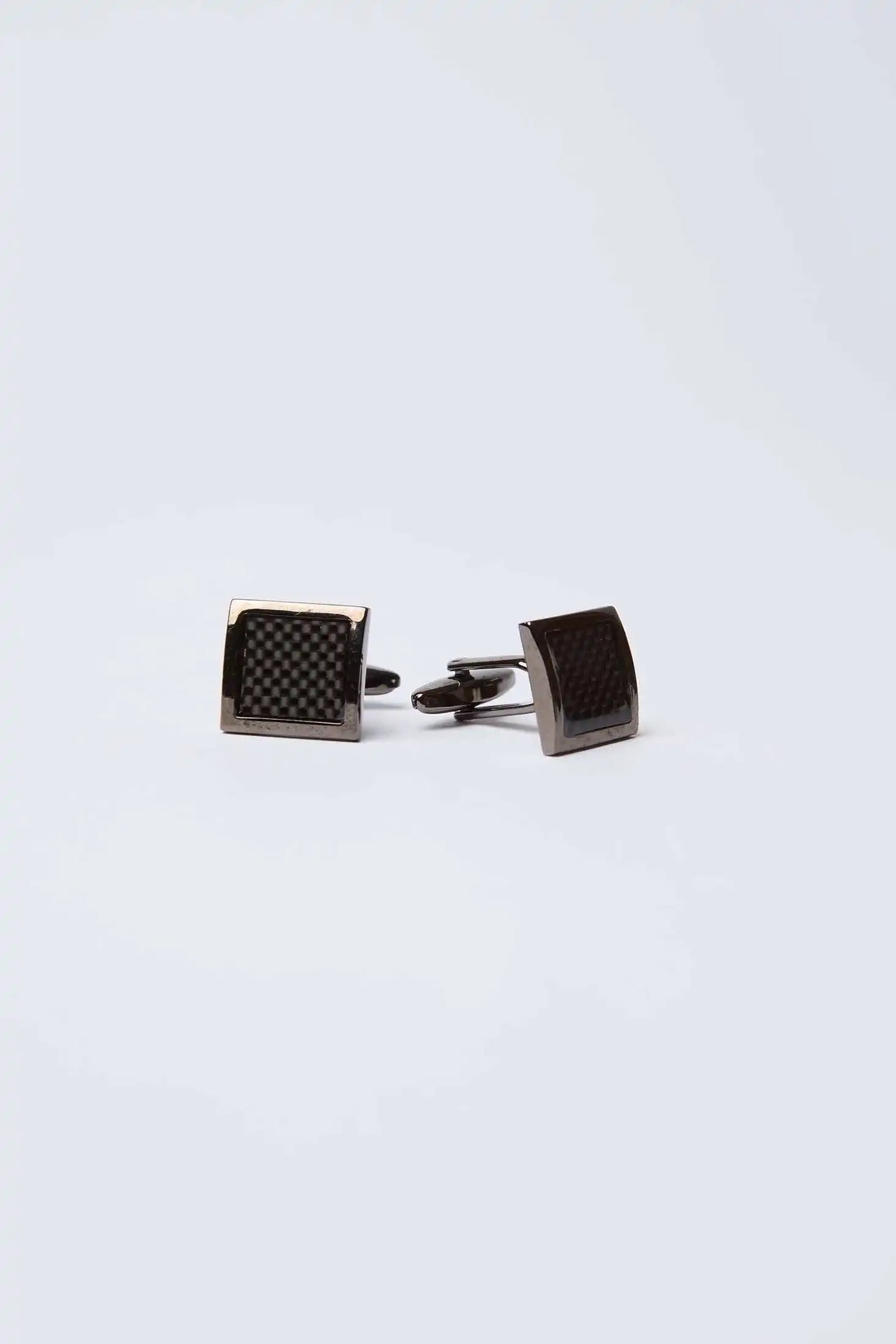 Pair of black square cufflinks with textured pattern on white background