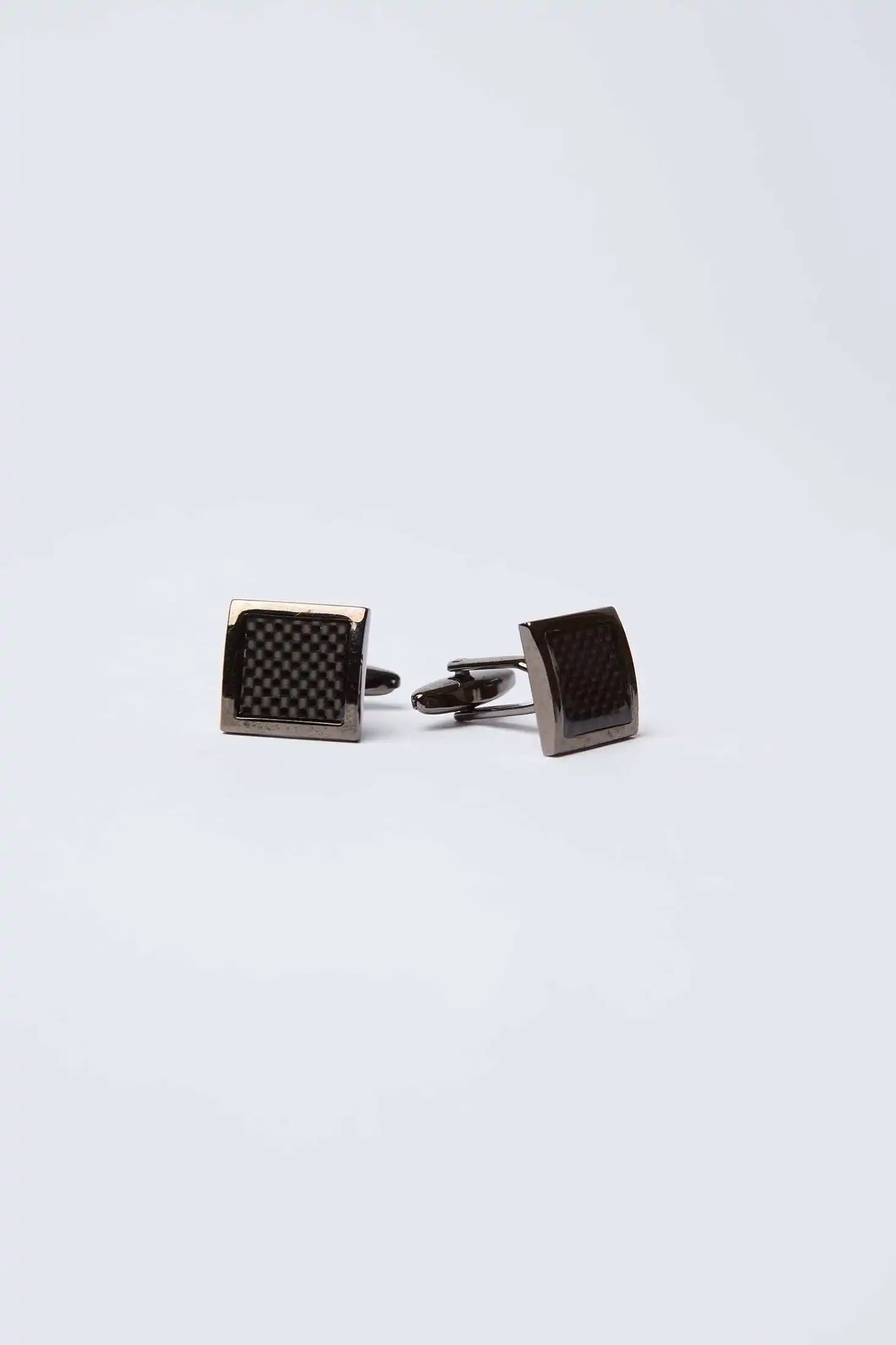 Pair of black square cufflinks with textured pattern on white background