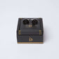 Black and silver round cufflinks on a dark gift box with gold accents, men's accessories