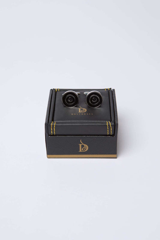 Black and silver round cufflinks on a dark gift box with gold accents, men's accessories