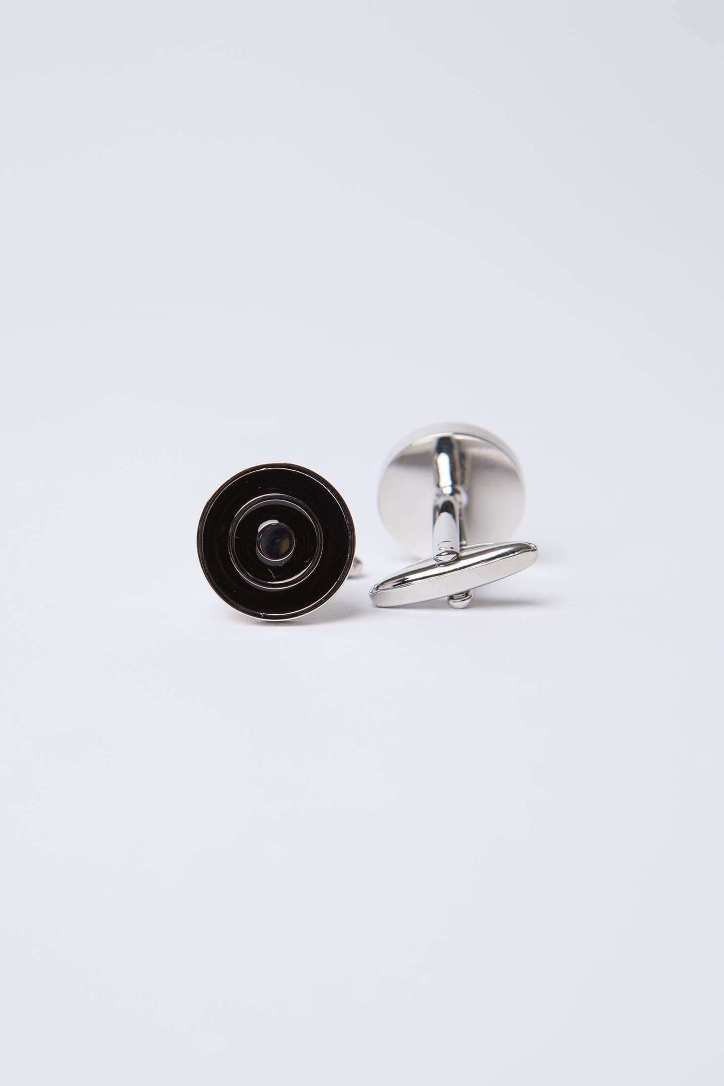 Silver round cufflinks with black concentric circle design on white background