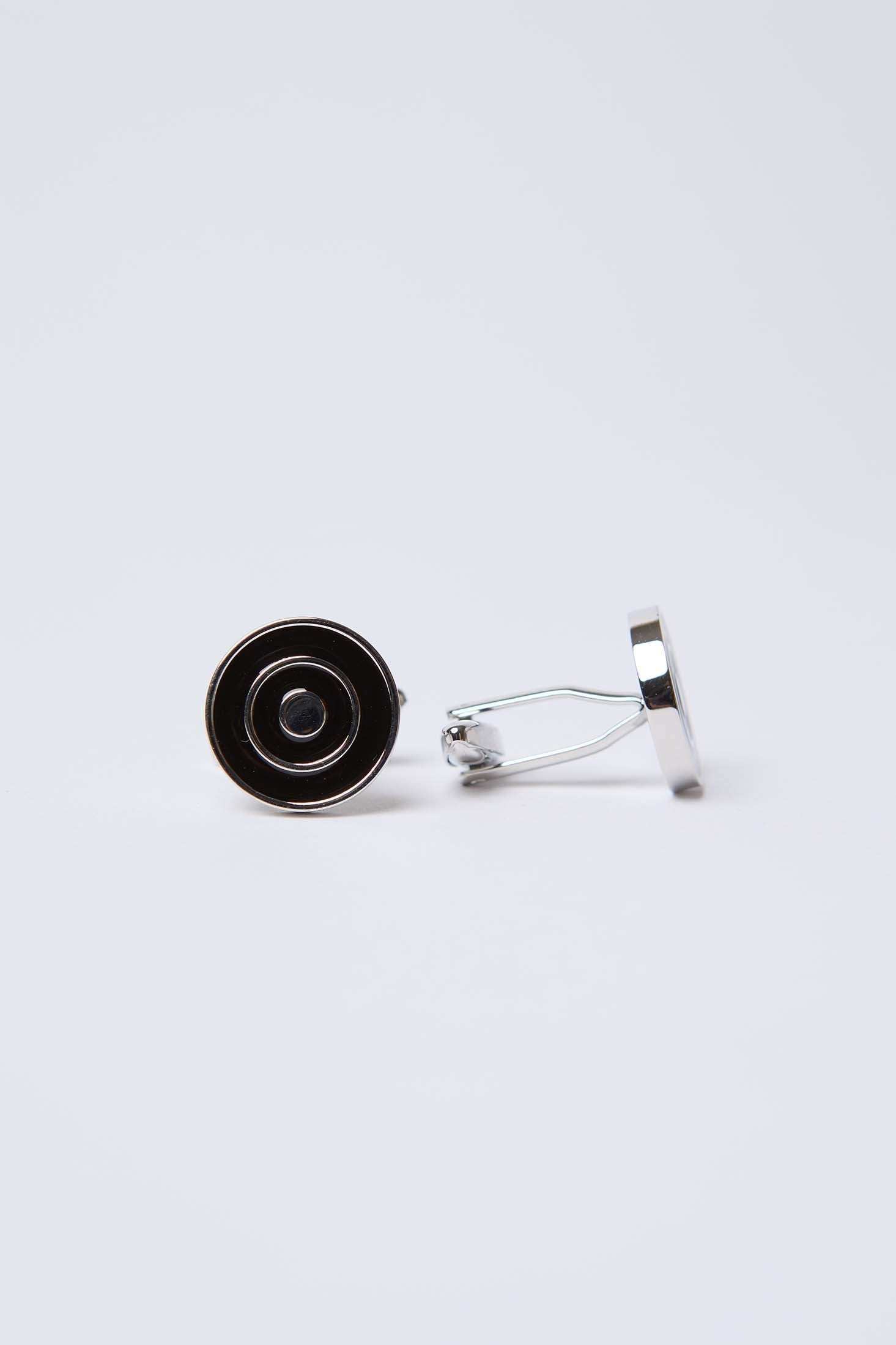 Silver and black round cufflinks with concentric circles on white background