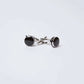 Pair of round black and silver cufflinks on a plain white background