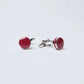 Pair of round red and silver cufflinks on a plain white background