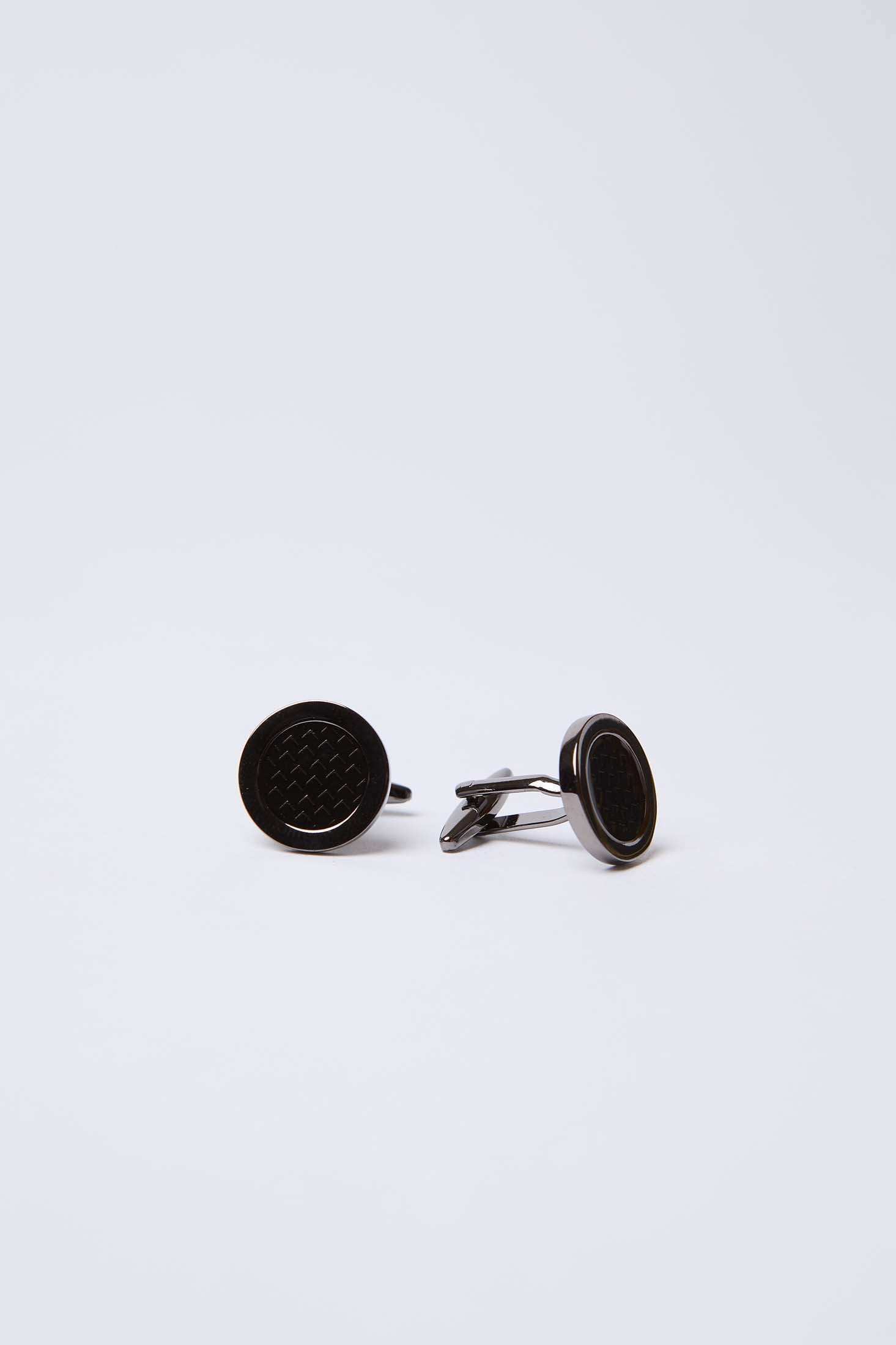 Round black cufflinks with textured center on plain white background