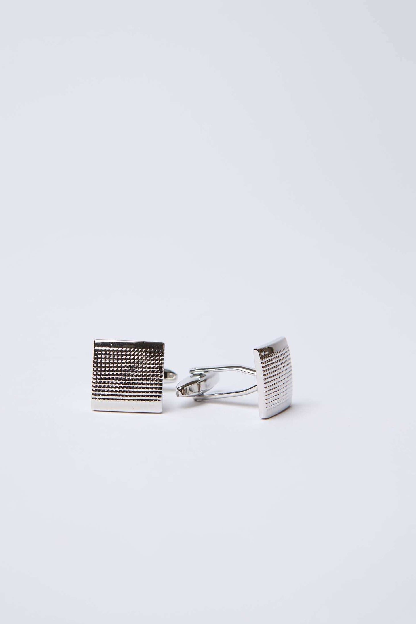 Silver square textured cufflinks on white background, men's accessories