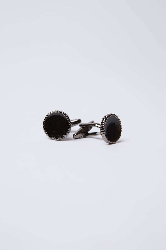 Elegant round black cufflinks with silver textured edge on a plain white background