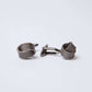 metal knot design cufflinks on white background, men's accessory closeup