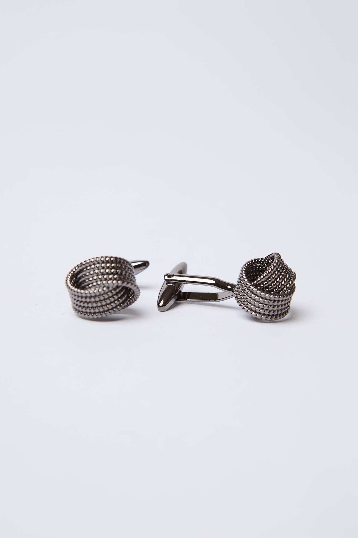 metal knot design cufflinks on white background, men's accessory closeup