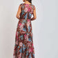 Woman in a sleeveless, floral print maxi dress with pink, blue, and brown tropical patterns