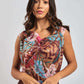 Woman wearing a sleeveless floral printed dress with brown, blue, and pink patterns