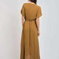 Woman wearing a brown belted maxi dress with short sleeves, photographed from the back