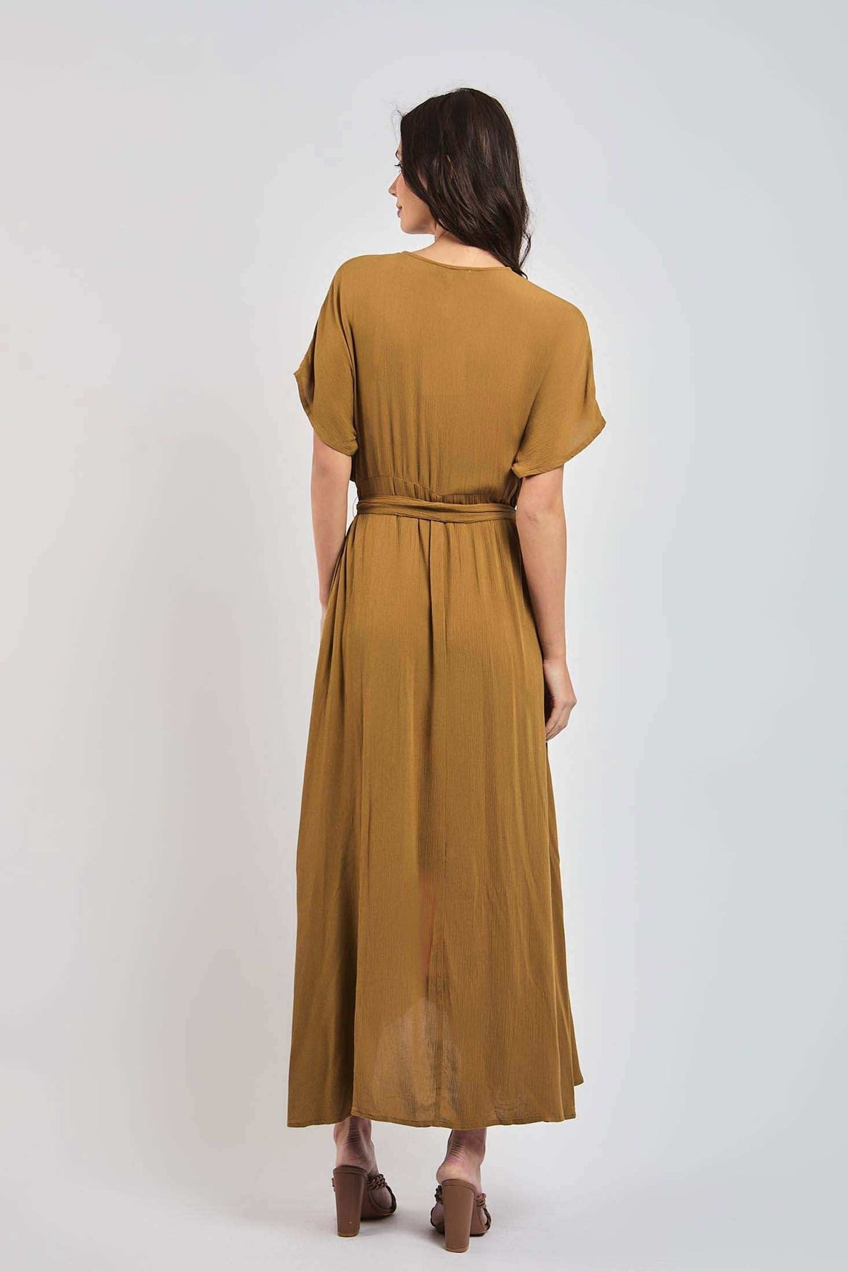 Woman wearing a brown belted maxi dress with short sleeves, photographed from the back