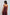Woman wearing burgundy sleeveless V-neck top and matching pleated pants, back view