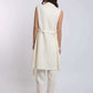 Woman wearing sleeveless cream belted tunic and wide-leg pants set, rear view