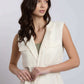 Woman wearing sleeveless cream belted vest with flap pockets, casual urban style