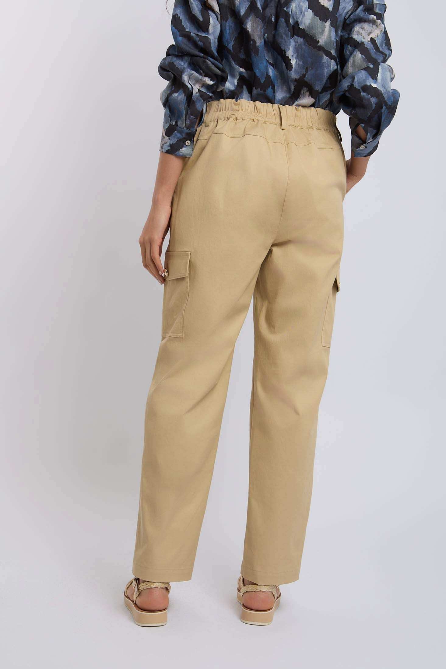 Woman wearing beige cargo pants with side pockets, back view, casual fashion style