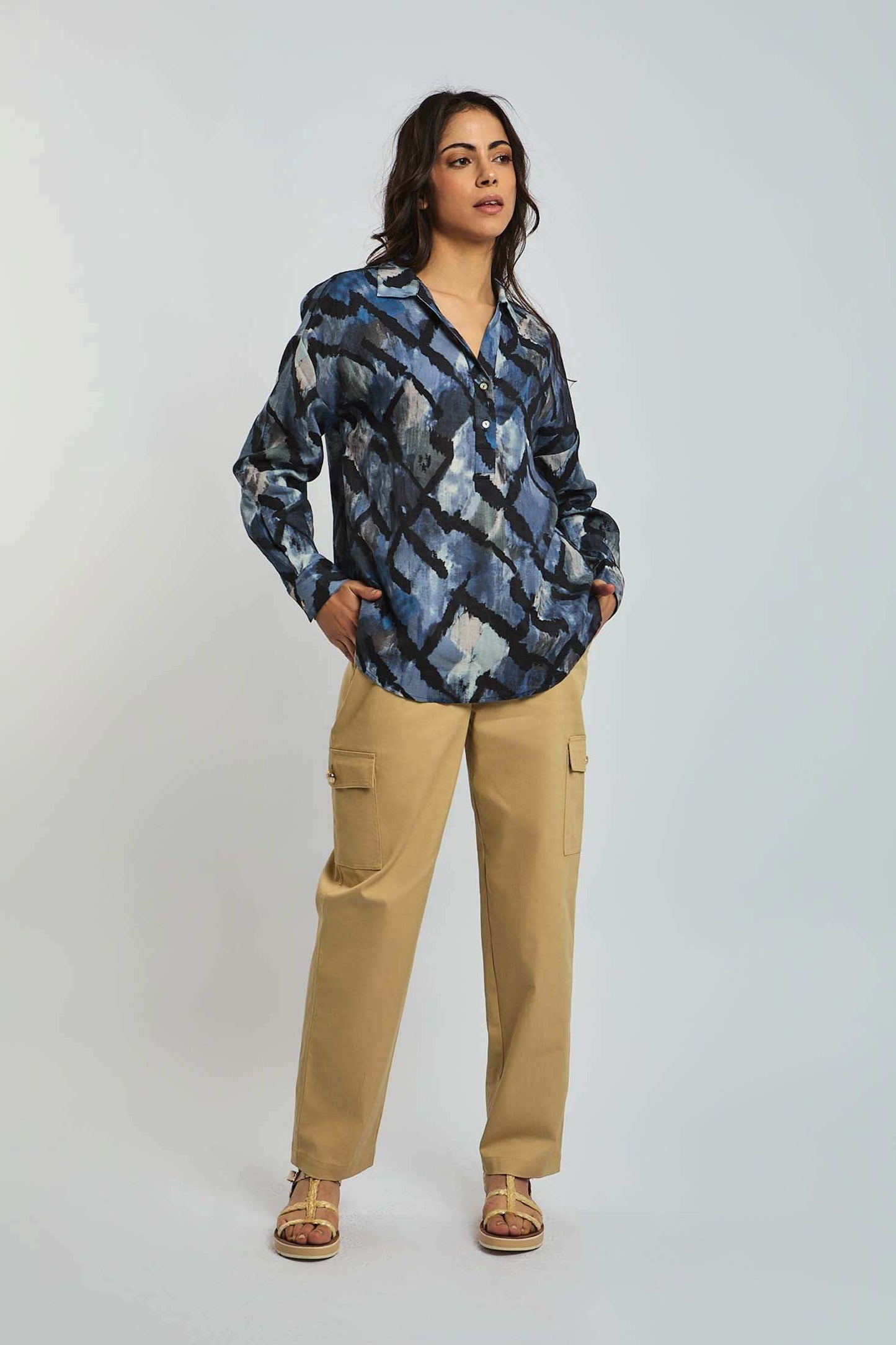 Woman wearing blue abstract print blouse and beige cargo pants, casual fashion look